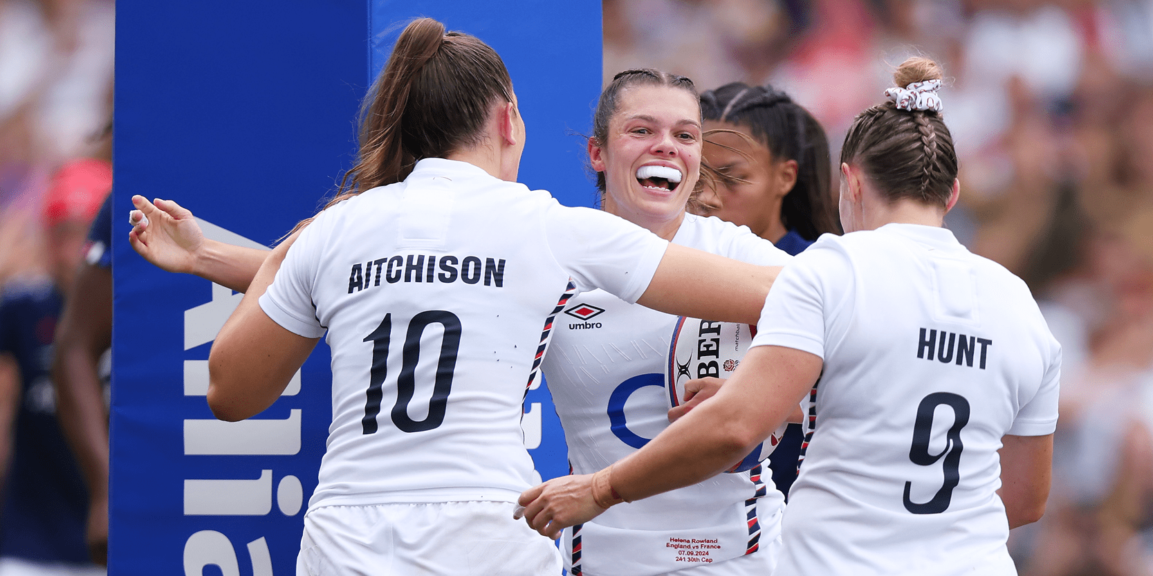England's Red Roses players smiling and celebrating scoring a goal during a match