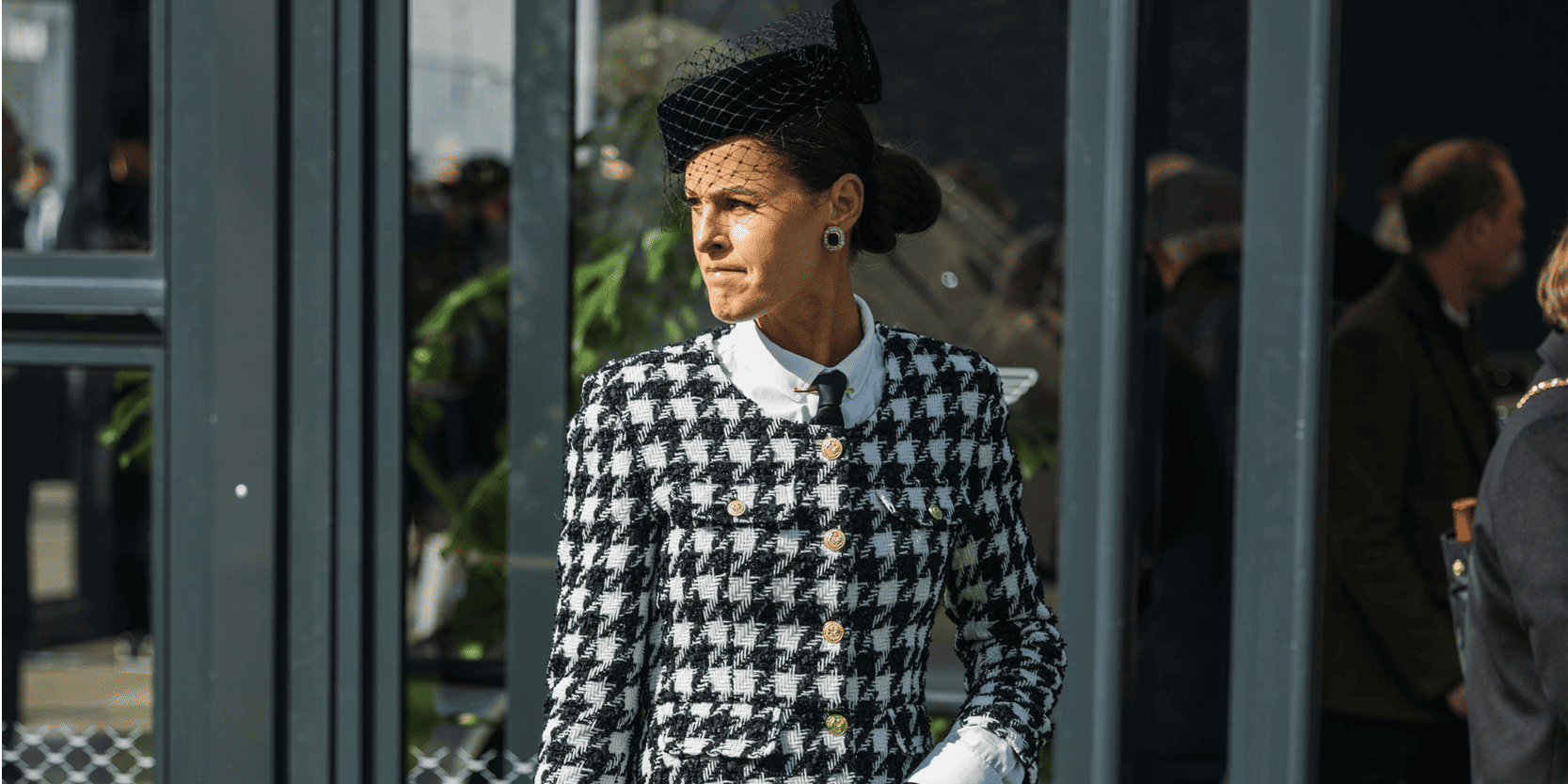 A lady dressed in a smart black and white tweed suit in hospitality at Cheltenham Festival