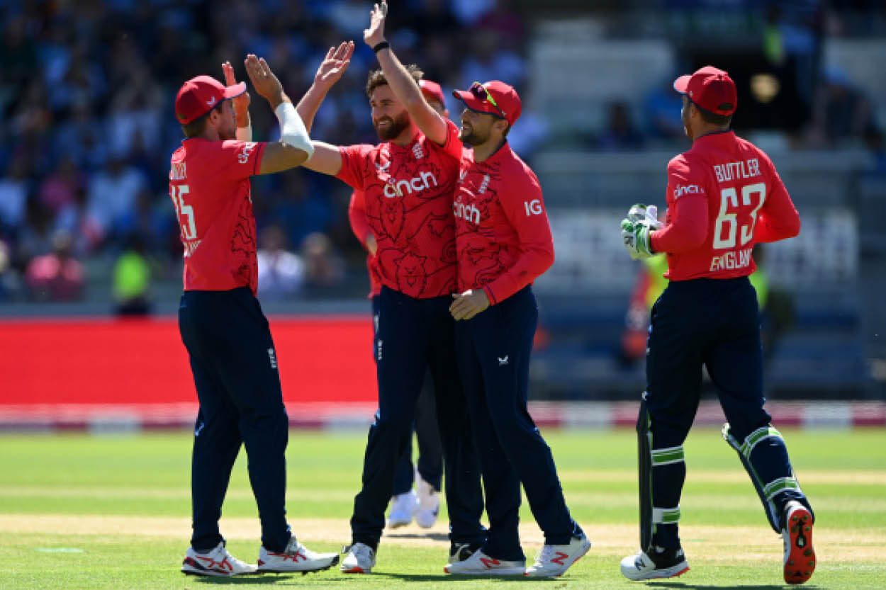 England team high diving and celebrating in a T20 match on the cricket pitch featuring Jos Butler